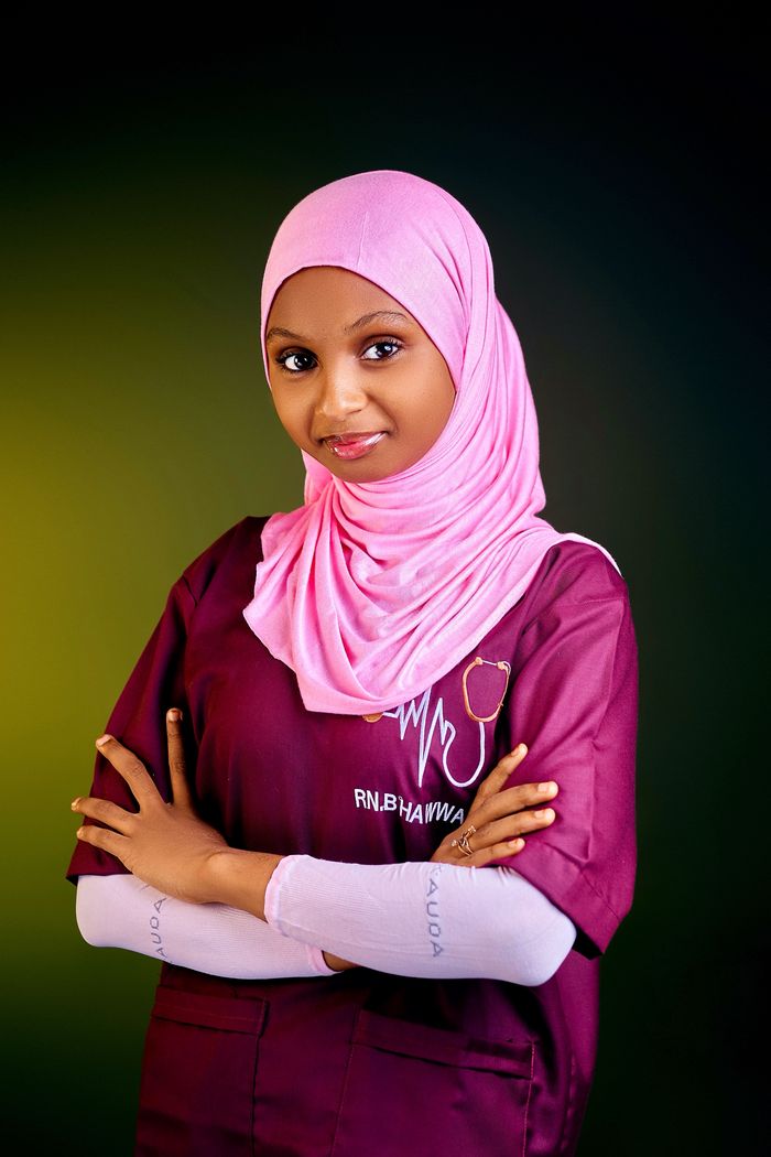 home-hero Portrait of a young nurse wearing a pink hijab with crossed arms, symbolizing confidence and professionalism.