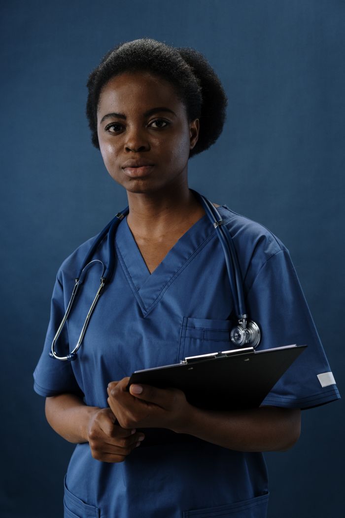 services-bg Professional nurse in blue scrubs holding a clipboard, conveying confidence and care.